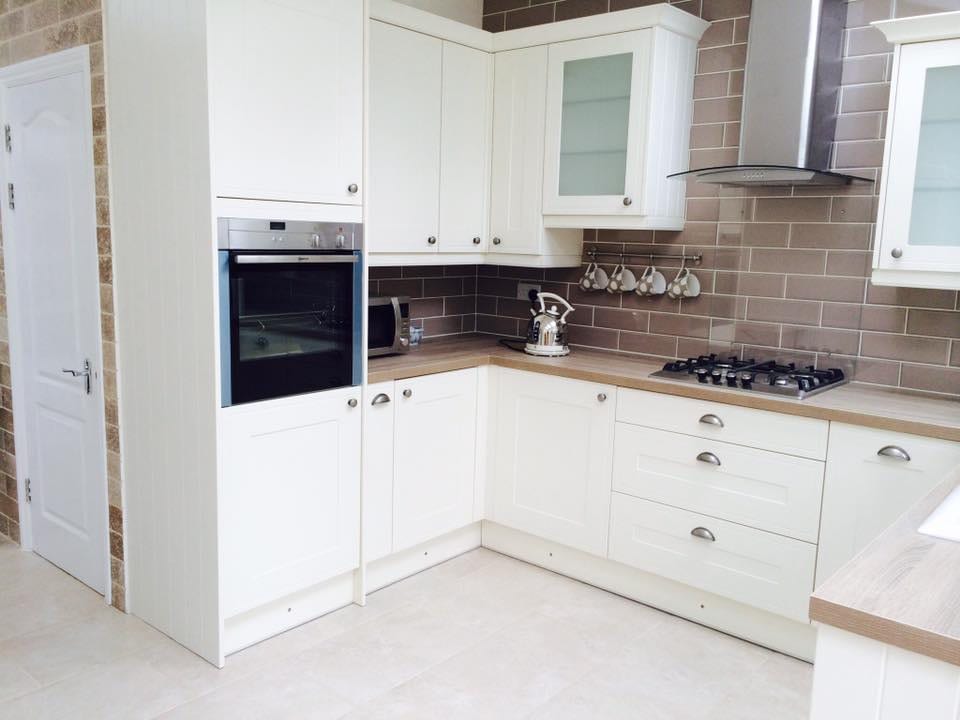 Fitted kitchen with integrated oven, gas hob and extractor hood