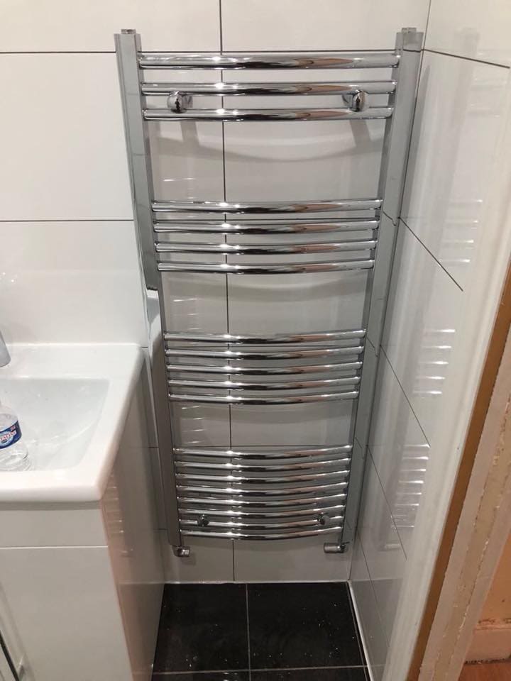 Tiled bathroom with bath and chrome towel radiator