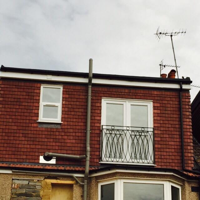 Rear loft conversion with new windows and Juliet balcony on a brick terrace